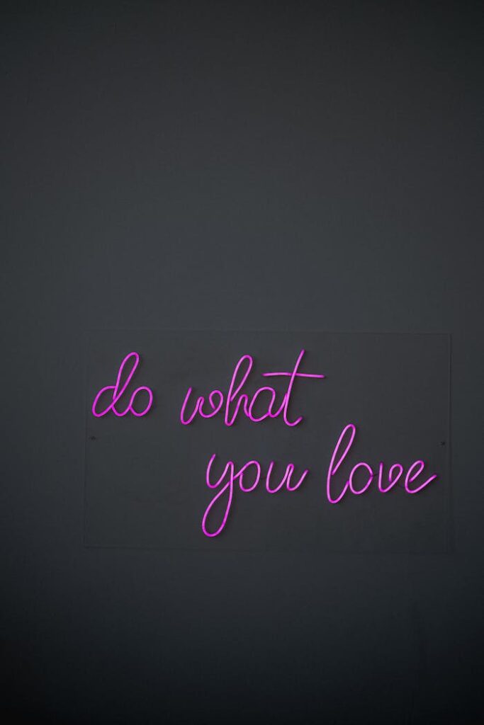 Purple neon sign reading 'do what you love' against a dark background, perfect for modern decor.